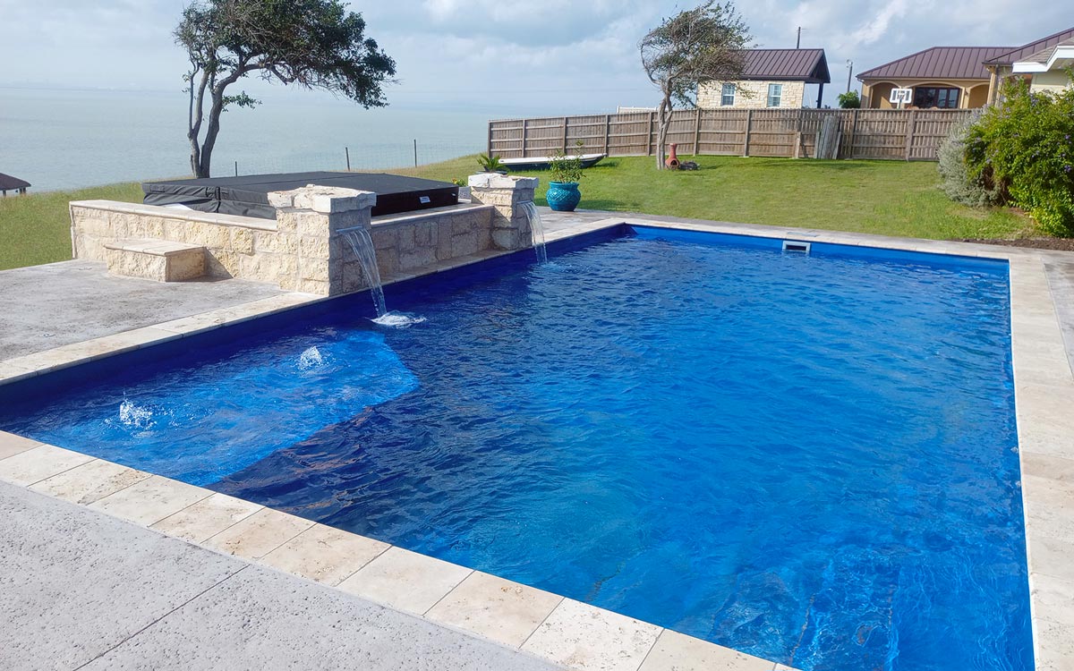 ICF POOL. FEATURES: CORNER BENCH/LEDGE, BUBBLERS, WATER FEATURES, ELEVATED SPA (SEPARATE). DECKING: ROCK SALT CONCRETE DECK. PORTLAND, TX.